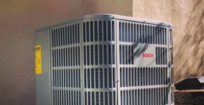 Residential AC condenser unit installed beside Long Island home